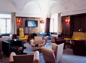 a waiting room with couches and tables and chairs at Parkhotel Laurin in Bolzano