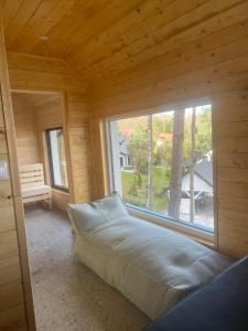 Bett in einem Zimmer mit einem großen Fenster in der Unterkunft Drewniany Domek nad Doliną Dunajca in Zakliczyn