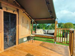 a screened in porch with a couch on a deck at Luxe safaritent in Ballum