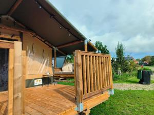 a wooden deck with a bed on top of it at Luxe safaritent in Ballum