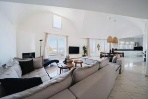 a large living room with a large couch and tables at The Zen Villa in Akrotiri