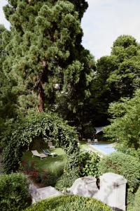 a garden with a tree and a swimming pool at Parkhotel Laurin in Bolzano