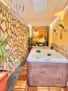 a bath tub in a bathroom with a stone wall at Suite Apartment Capri con Jacuzzi in Piazzetta in Capri