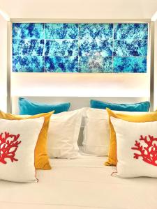 a bed with white pillows and a blue wall at Suite Apartment Capri con Jacuzzi in Piazzetta in Capri