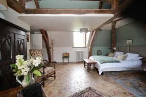 a bedroom with a bed and a vase of flowers at Le Petit Serrant - maison d'hôtes d'exception in Bouchemaine