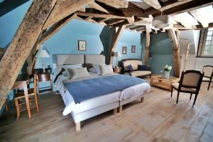 a bedroom with a bed and a living room at Le Petit Serrant - maison d'hôtes d'exception in Bouchemaine