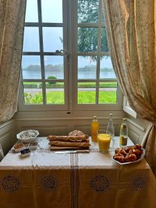 een tafel met eten voor een raam bij Le Petit Serrant - maison d'hôtes d'exception in Bouchemaine