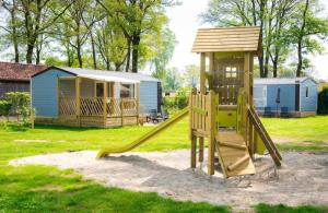een speeltuin met een glijbaan en een huis bij Safaritent of Chalet in Neede