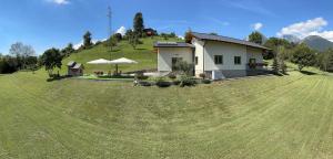ein Haus auf einem großen Grasfeld in der Unterkunft Origini Holidays in Sedico