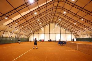 利維夫的住宿－LH酒店及Spa，一群人在网球场打网球