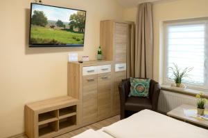 a room with a chair and a television on the wall at Haus Mila in Bienenbüttel