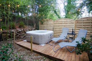 a hot tub sitting on a wooden deck with chairs at VILLA ISABELLE -2 Appartements - 2 Jacuzzi privatifs in Saint-Étienne-de-Fontbellon