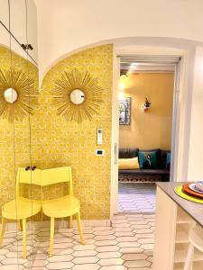 a dining room with a table and yellow chairs at Suite Apartment Capri con Jacuzzi in Piazzetta in Capri