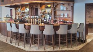 a bar with a row of stools in a room at Gold Coast Resort Dungarvan in Dungarvan