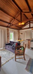 a living room with a purple couch and a table at Pouso Mantiqueira in Cunha