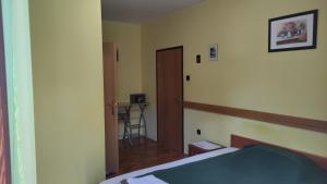 a bedroom with a bed and a door and a table at Mirna noć in Zagreb