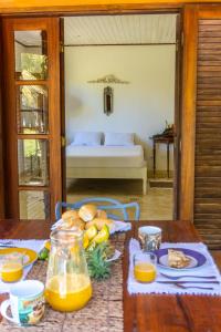 een tafel met een bord eten en sinaasappelsap bij Villa Arandis in Marau