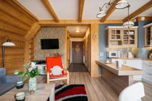 a kitchen and living room in a log cabin at Apartament Skibówki by LoftAffair in Zakopane