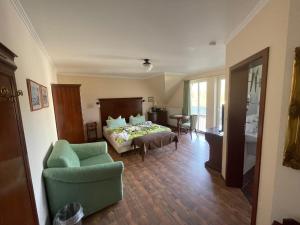 a bedroom with a bed and a couch and a chair at Hotel Windflüchter in Breege