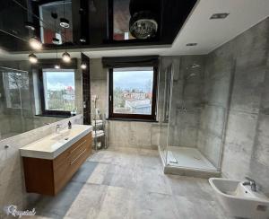 La salle de bains est pourvue de 2 lavabos, d'une baignoire et d'une douche. dans l'établissement Hotel Crystal, à Janikowo
