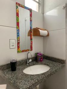 encimera con lavabo y espejo en Casa Recanto das Dunas, en Santo Amaro