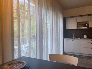 a kitchen with a table and a large window at Apartment Villa Huber in Bolzano