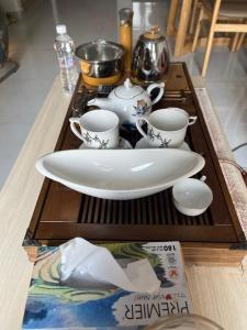 a table with a plate and cups on a wooden tray at Khu Nghĩ Dưỡng Emerald Golf View in Thuan An