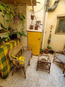 eine Terrasse mit einem Tisch, Stühlen und einer Gitarre in der Unterkunft Cute Townhouse in Maltese Village Close To St Peters Pool in Żejtun