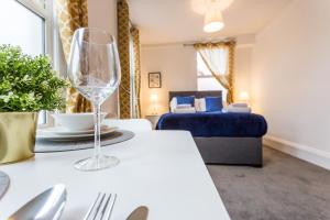een woonkamer met een wijnglas op een tafel bij West Street Studio Apartments in Southend in Southend-on-Sea