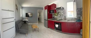 - une cuisine avec des placards rouges et un évier dans l'établissement Le Cacique 012, à Grand-Bourg