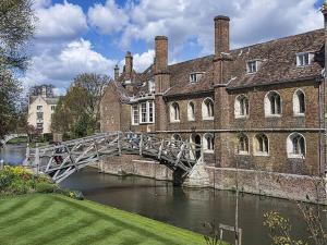 a bridge over a river in front of a building at Stylish Cambridge Home with free parking in Cambridge