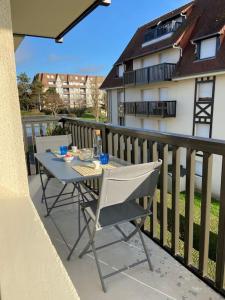 een tafel en stoelen op een balkon bij L'Appart 204, Superbe Appartement en Résidence in Villers-sur-Mer +20 foto's