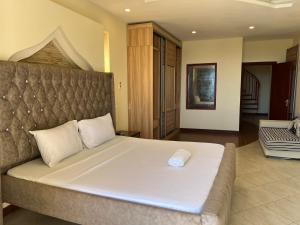 a bedroom with a large bed with a white mattress at The penthouse beachfront in Mombasa