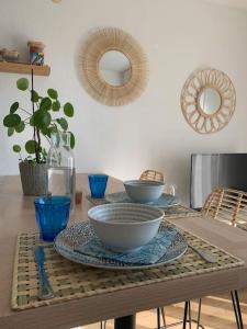een tafel met kommen en borden erop bij L'Appart 204, Superbe Appartement en Résidence in Villers-sur-Mer