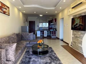 The penthouse beachfront في مومباسا: غرفة معيشة مع أريكة وطاولة
