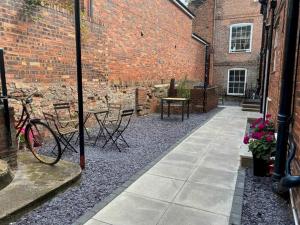 チェスターにあるMoray Court Chester City Centre Studio Apartment by Rework Accommodationのレンガ造りの建物内にパティオ(テーブル、椅子付)