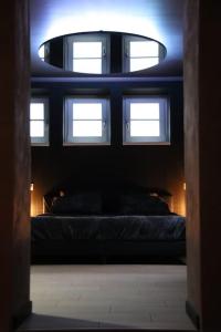 a dark room with a bed and a round window at Les Secrets du Château - Love Room in Lichtenberg +7 photos