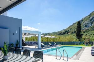 uma villa com uma piscina com montanhas ao fundo em Del Sur Luxury Villa, Absolute Privacy & Comfort, By ThinkVilla em Lefkogeia