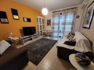 a living room with a couch and a tv at Pretty Home in Acireale