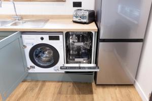 a washer and dryer in a kitchen next to a sink at Blenheim Palace Lodge Retreat in Woodstock