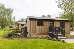 a log cabin with a porch and a lawn at Blenheim Palace Lodge Retreat in Woodstock