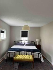 1 dormitorio con 1 cama grande y banco amarillo en A Winfield Bungalow, en Dover