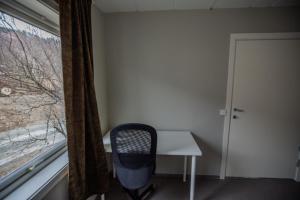 um quarto com uma secretária, uma cadeira e uma janela em Nordpå Hub em Haltdalen