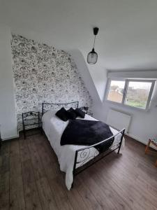 1 dormitorio con 1 cama con pared estampada en La Désirade Audresselles, charmante maison à 250 m de la plage, en Audresselles