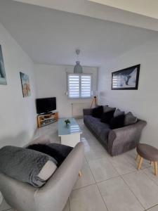 sala de estar con 2 sofás y TV en La Désirade Audresselles, charmante maison à 250 m de la plage, en Audresselles