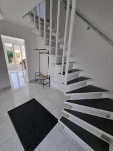 a staircase in a house with black and white carpet at La Désirade Audresselles, charmante maison à 250 m de la plage in Audresselles