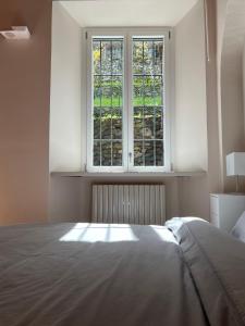 1 dormitorio con cama y ventana en LA VOLTA - ANTESITUM - historic, on the lake, en Malgrate