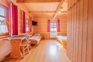 a room with two beds and a desk in a cabin at Domek Góralski Na Pastwisku in Małe Ciche