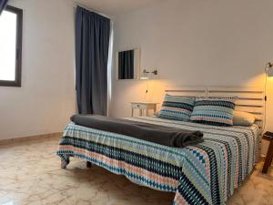 ein Schlafzimmer mit einem großen Bett mit blauen Kissen in der Unterkunft Alquilaencanarias- Medano Amanecer Cabezo Beach in El Médano