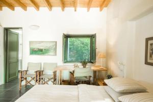 a bedroom with a bed and a table and chairs at Oleander Country House in Patmos